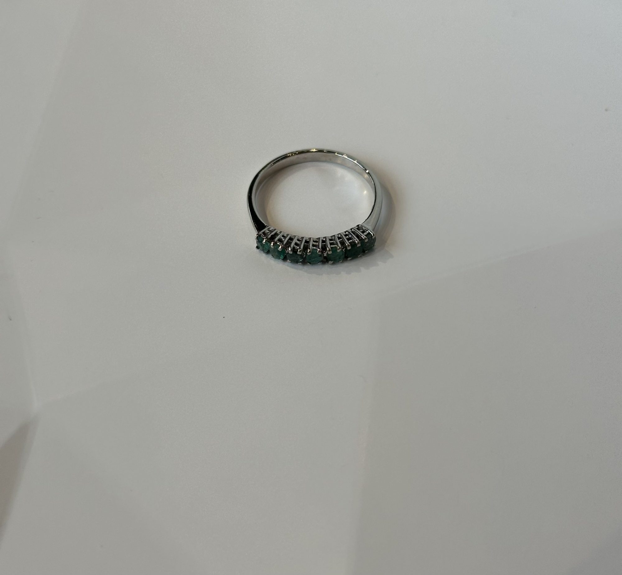 Witgouden memoirering met smaragd